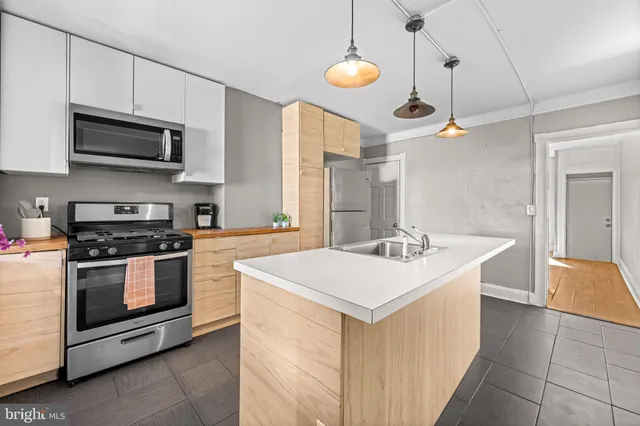 a kitchen with stainless steel appliances a stove a sink and a microwave