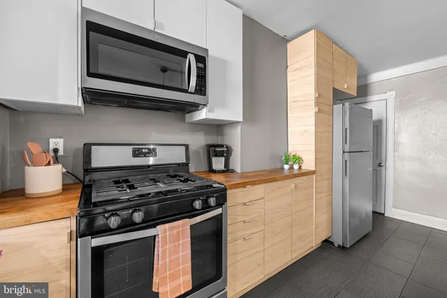 a kitchen with stainless steel appliances granite countertop white cabinets and a stove top oven