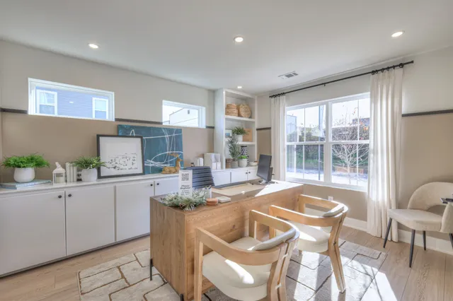 a dining hall with stainless steel appliances granite countertop a sink a stove a dining table and chairs