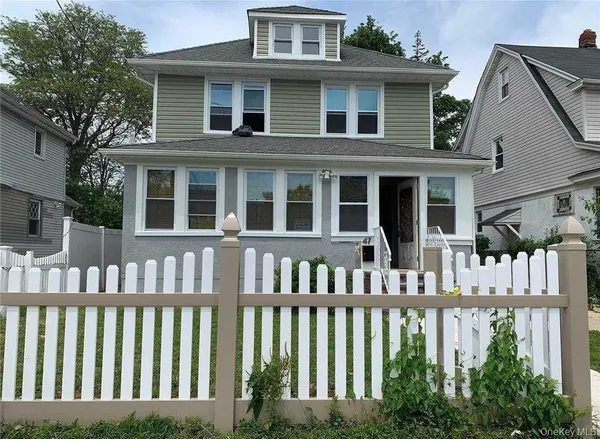 a front view of a brick house with a small yard