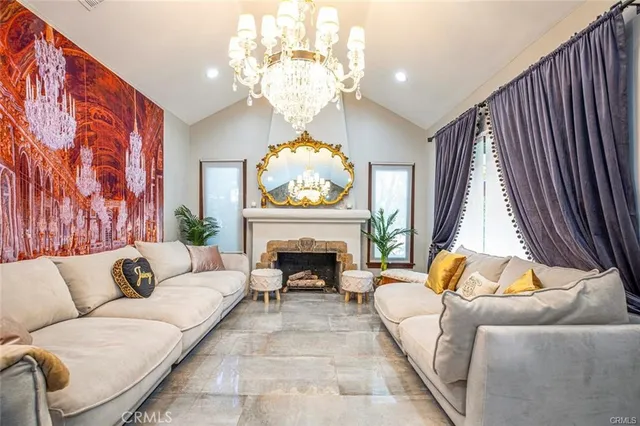 a living room with furniture a fireplace and a chandelier