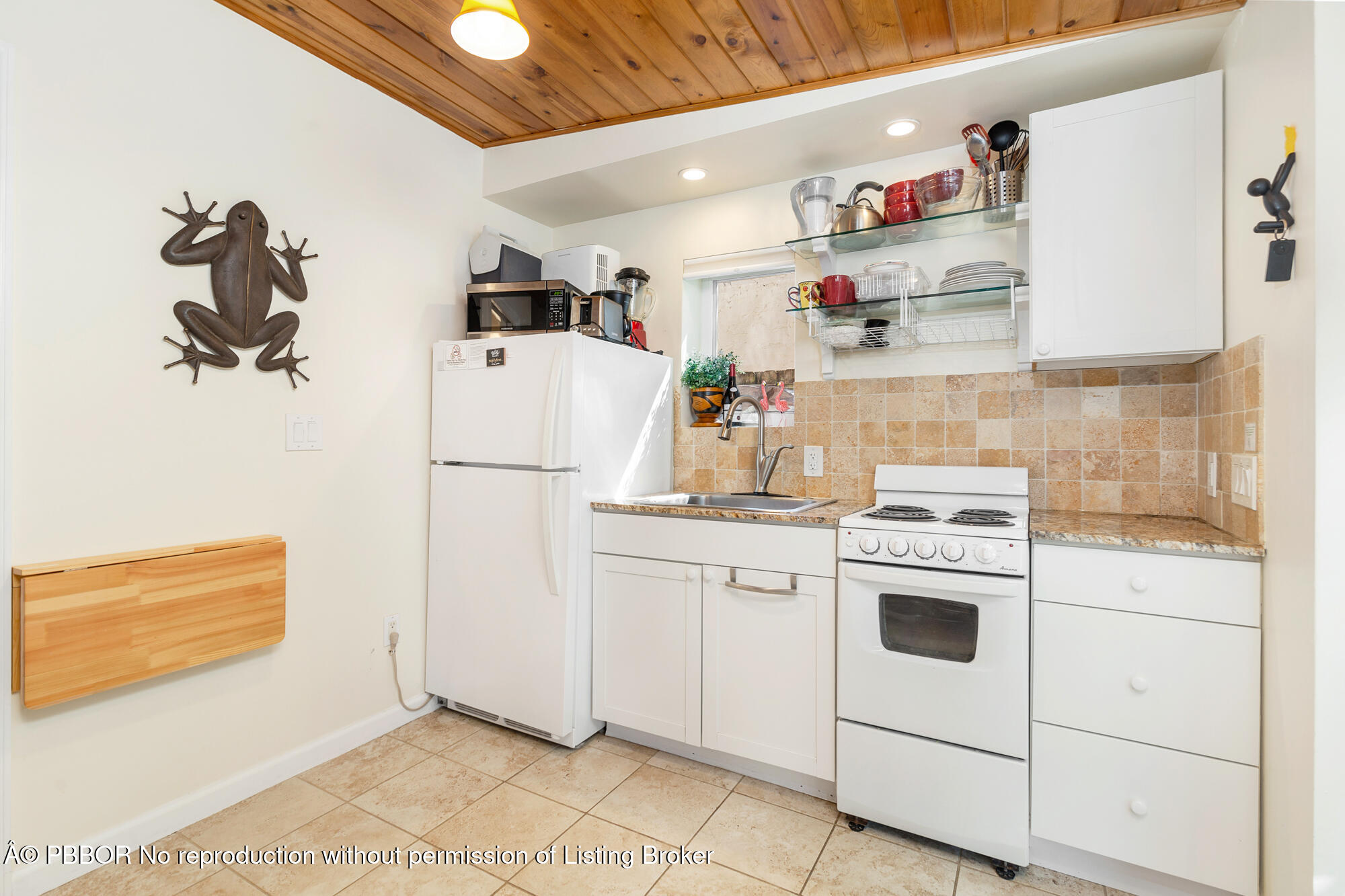 714 Sunset Road West Palm Beach, FL 33401 - Photo 14 of 18 a kitchen with refrigerator and cabinets