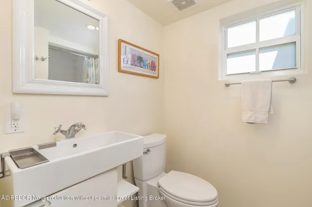 a white toilet sitting next to a bathroom sink
