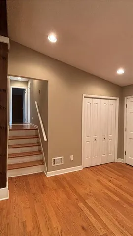 a view of a livingroom with wooden floor and stairs