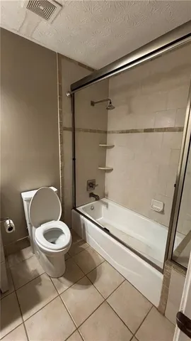 a bathroom with a granite countertop sink a toilet and a shower