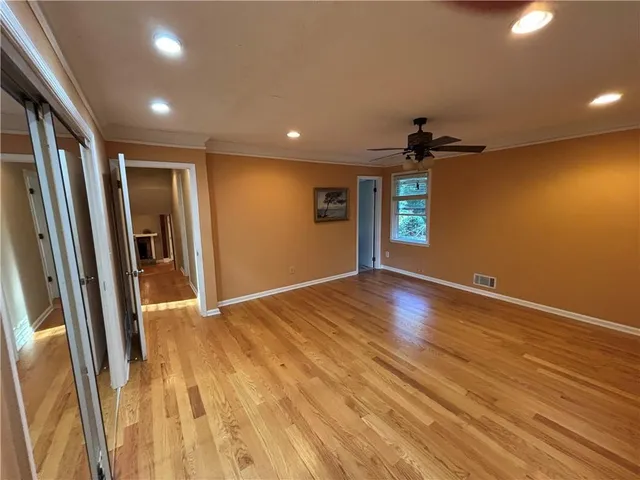 a view of empty room with wooden floor