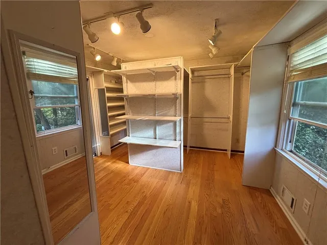 a view of empty room with wooden floor and window
