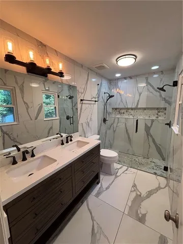 a bathroom with a double vanity sink mirror and toilet