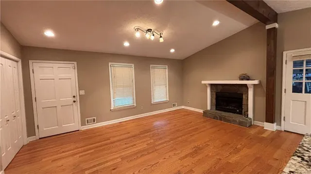 a view of an empty room with a fireplace and a window