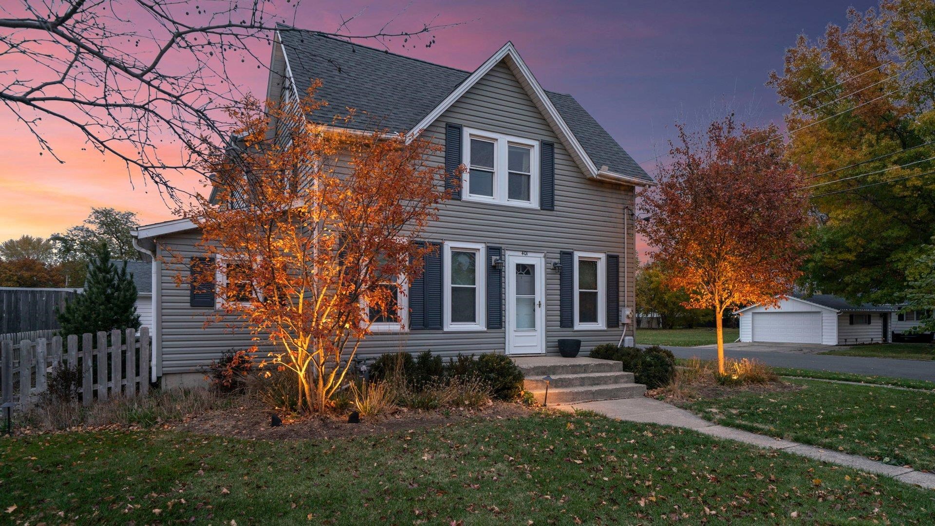 a front view of a house with a yard and trees