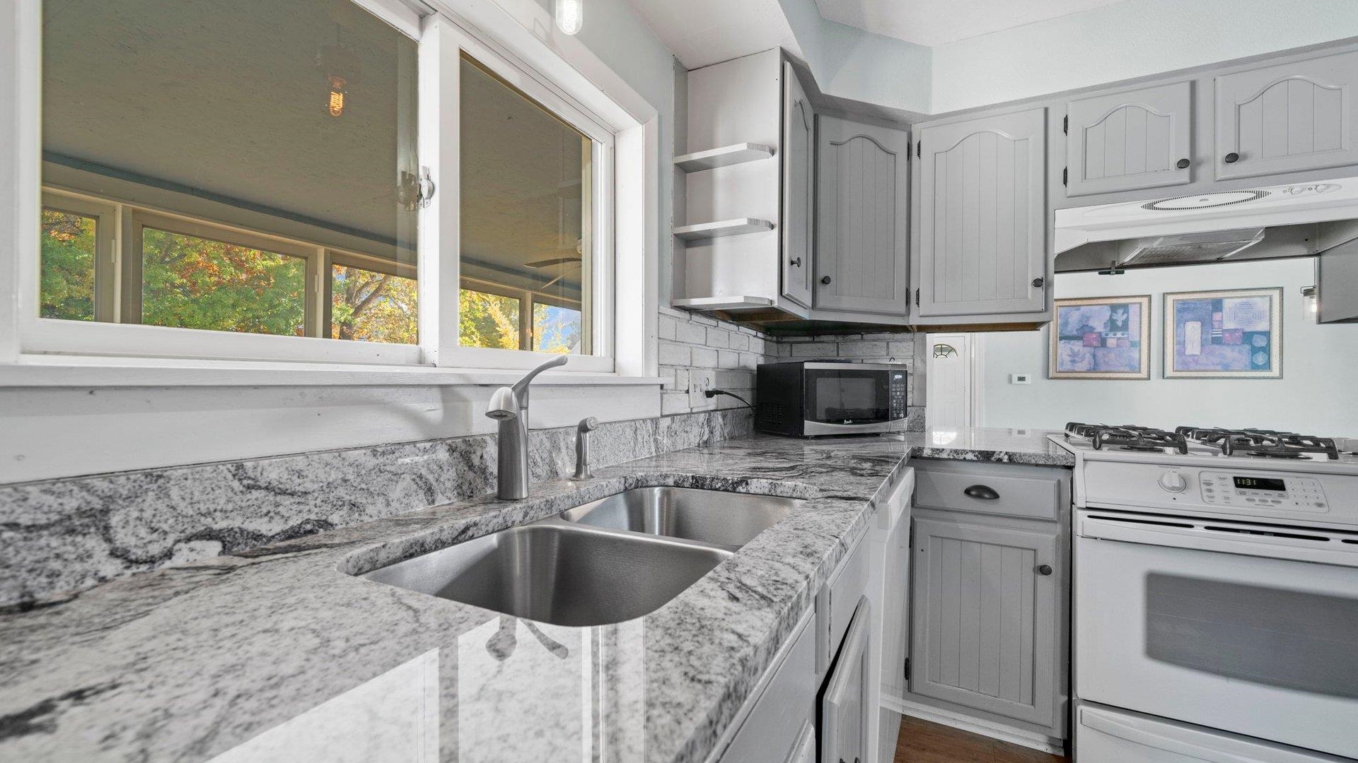 401 West 3rd Street Byron, IL 61010 - Photo 21 of 43 a kitchen with granite countertop a sink a counter space appliances and cabinets