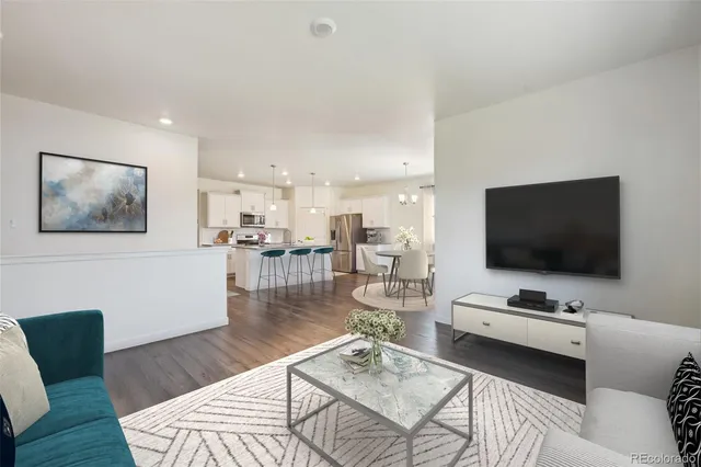 a living room with stainless steel appliances kitchen island granite countertop furniture a dining table and chairs