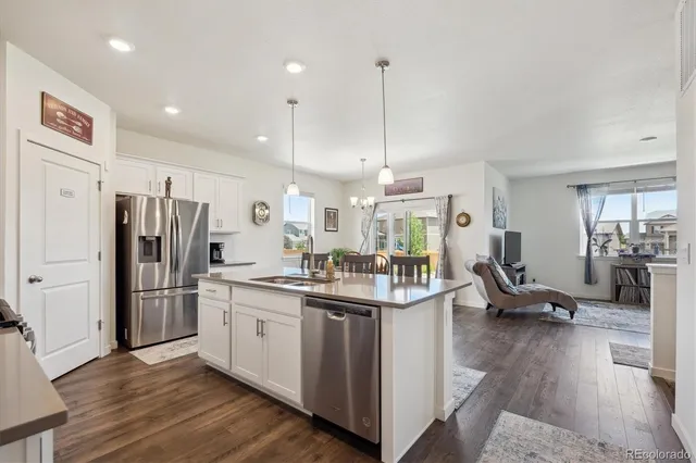 a kitchen with stainless steel appliances kitchen island granite countertop a dining table chairs and stove top oven