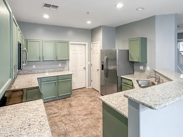 a kitchen with kitchen island a sink stove and refrigerator