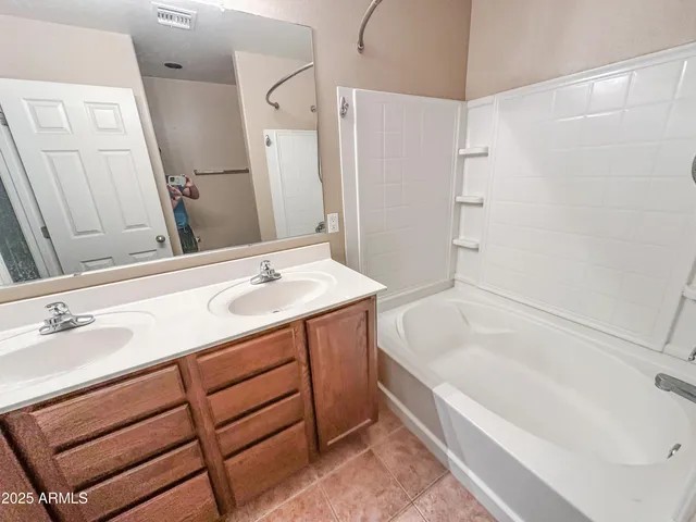 a bathroom with a tub sink and mirror
