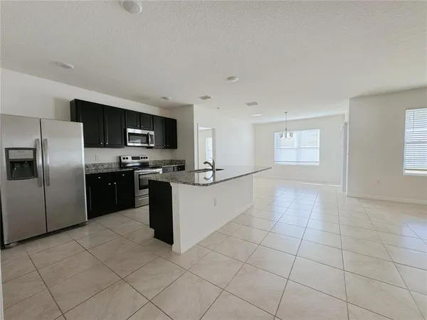 a kitchen with stainless steel appliances granite countertop a sink refrigerator and microwave