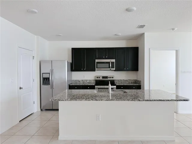 a view of a kitchen with furniture and an empty room