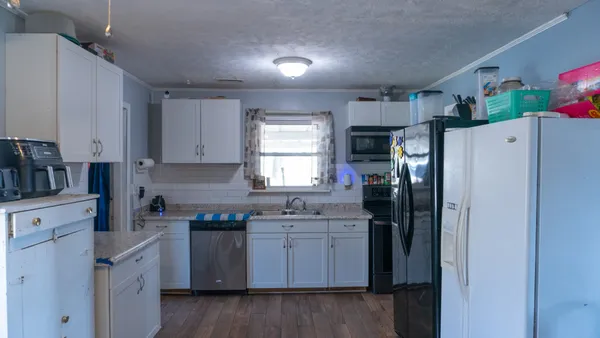 a kitchen with granite countertop a sink and a stove top oven