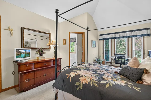 a bedroom with a bed and large windows