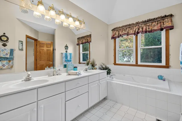 a bathroom with a tub sink and mirror