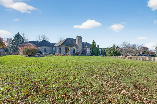 a view of a house with a big yard and large trees