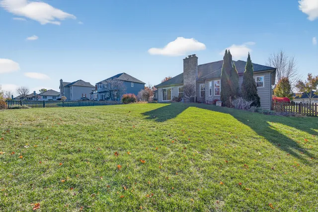 a view of a big house with a big yard and a large tree