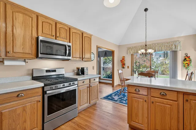 a kitchen with stainless steel appliances granite countertop a stove a sink and a microwave