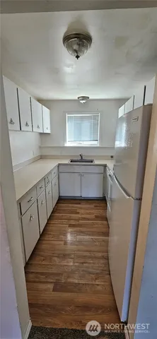 a kitchen with cabinets and wooden floor