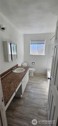 a bathroom with a sink a toilet and mirror