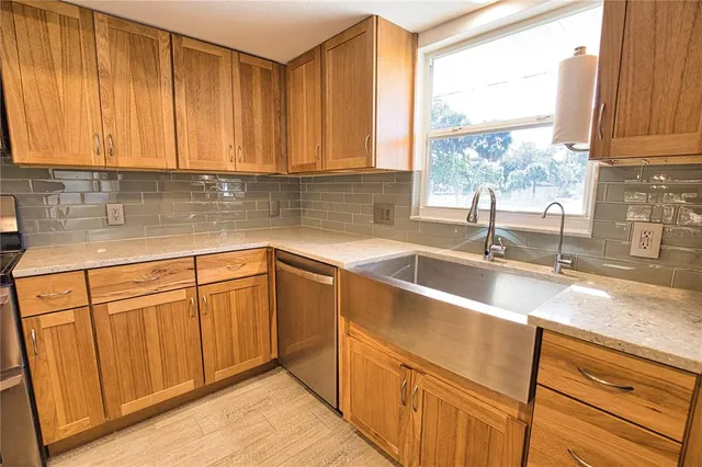 a kitchen with granite countertop sink and cabinets