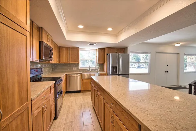 a large kitchen with stainless steel appliances granite countertop a lot of counter space and wooden floors