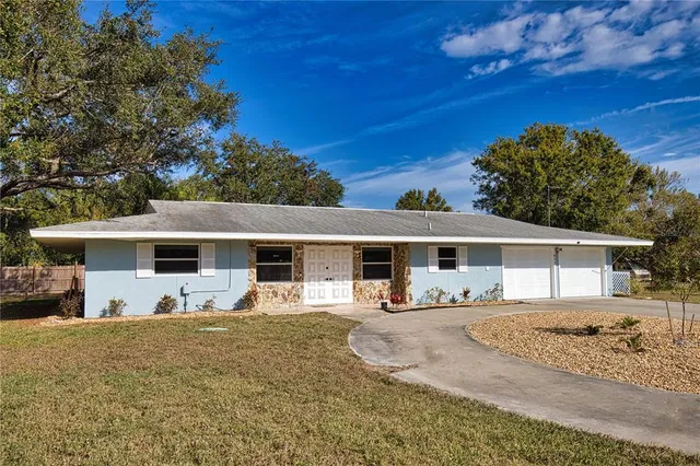 a front view of house with yard and trees in the background