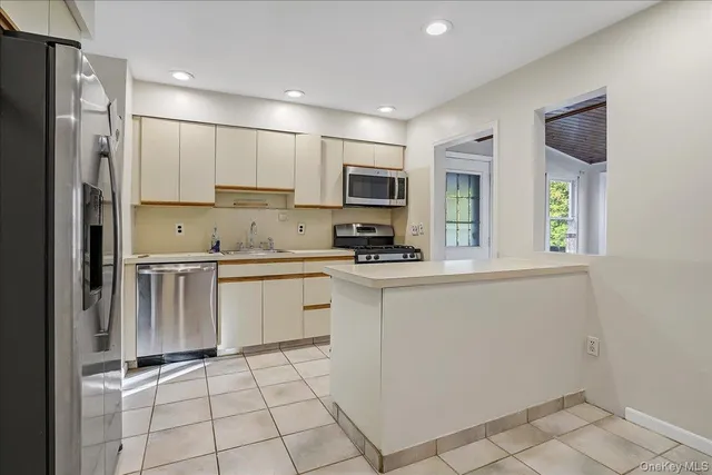 a kitchen with stainless steel appliances granite countertop a refrigerator and a stove top oven