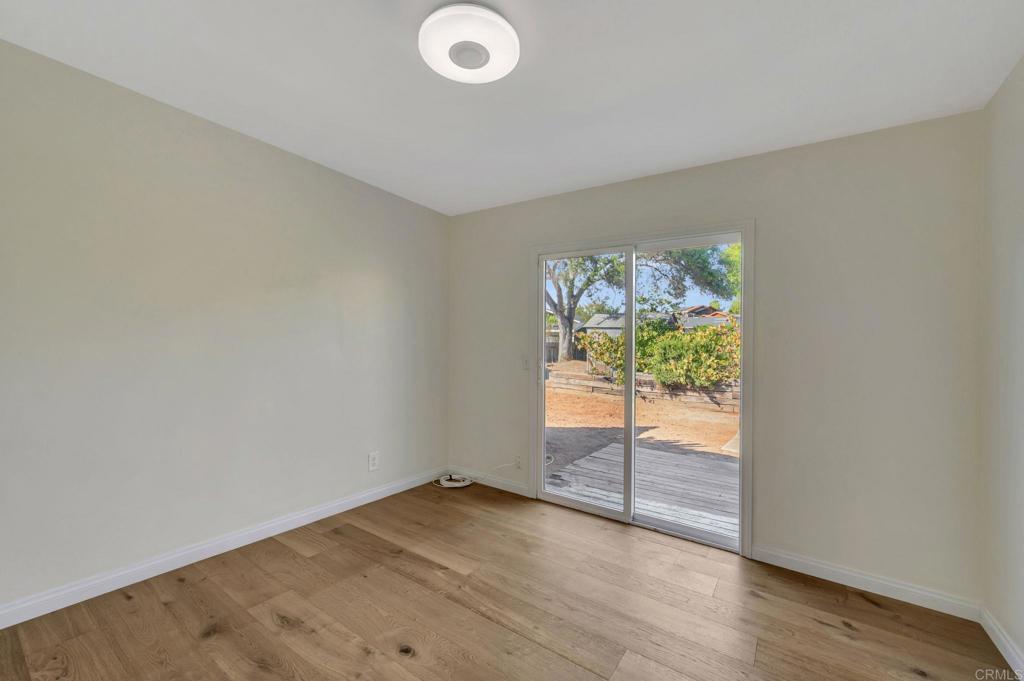 732 Osborne Street Vista, CA 92084 - Photo 23 of 44 an empty room with wooden floor and windows