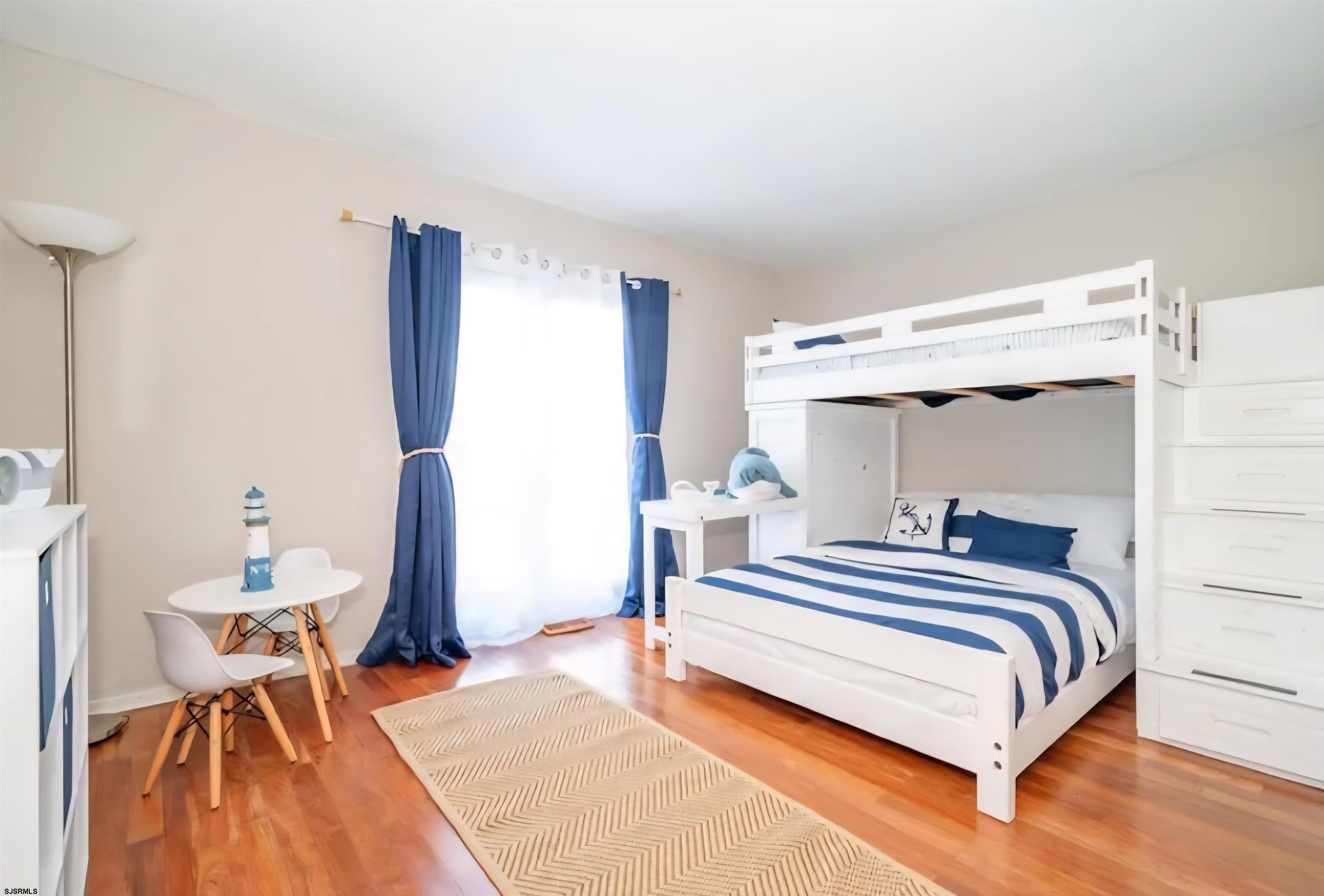 518 Casa Drive, Unit SUMMER RENTAL Brigantine, NJ 08203 - Photo 16 of 19 a bedroom with a bed and a table in it