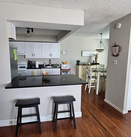 a kitchen with stainless steel appliances wooden floor dining table and chairs