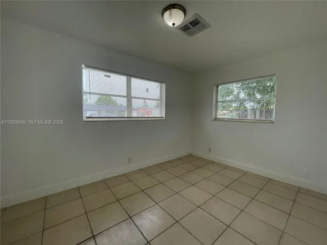 a backyard of a house with lots of plants and tree