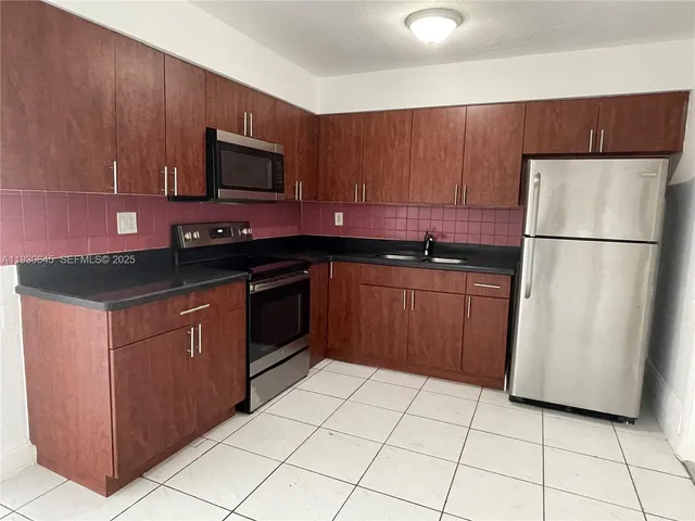 a kitchen with a sink a stove top oven and cabinets