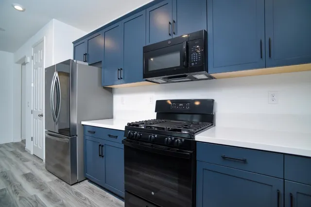 a kitchen with stainless steel appliances a stove a microwave and a refrigerator