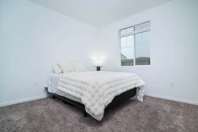 a bed sitting in a bedroom next to a window