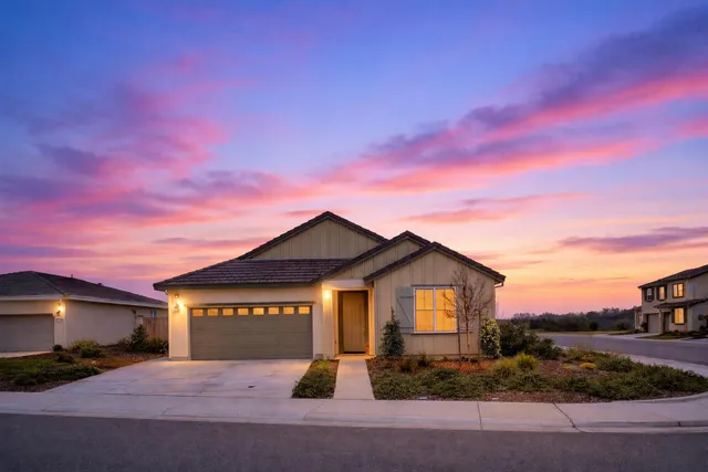 a front view of a house with yard and parking