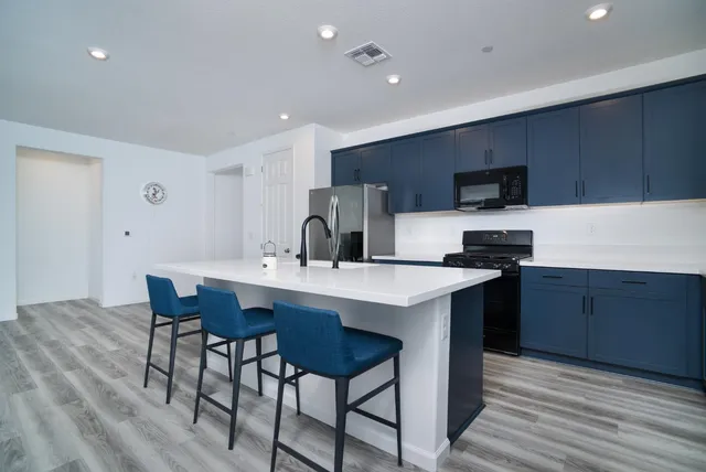 a kitchen with a sink a microwave and cabinets