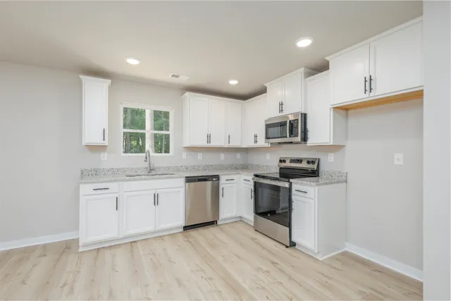 a kitchen with granite countertop appliances cabinets and a sink