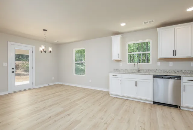 a kitchen with granite countertop white cabinets and window