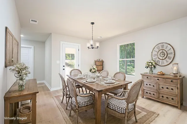 a dining room with furniture a chandelier and wooden floor