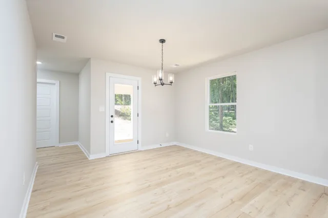 an empty room with windows and ceiling fan