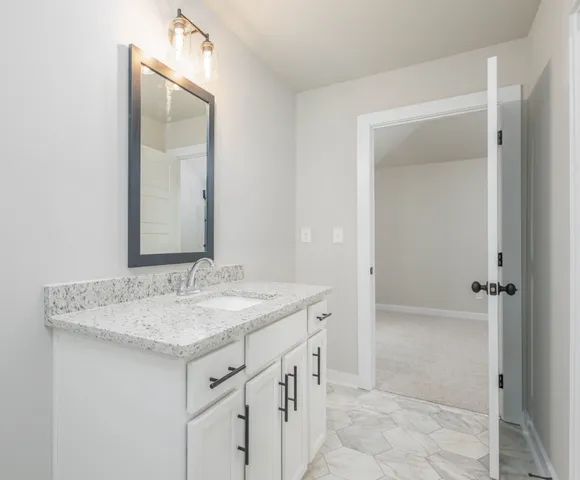 a bathroom with a granite countertop sink and a mirror