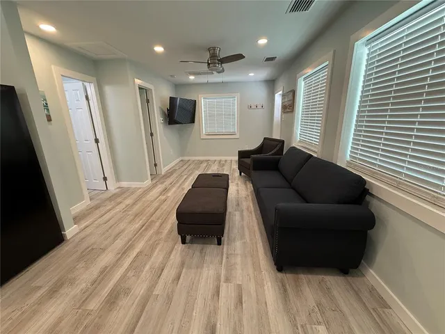 a living room with furniture and a wooden floor