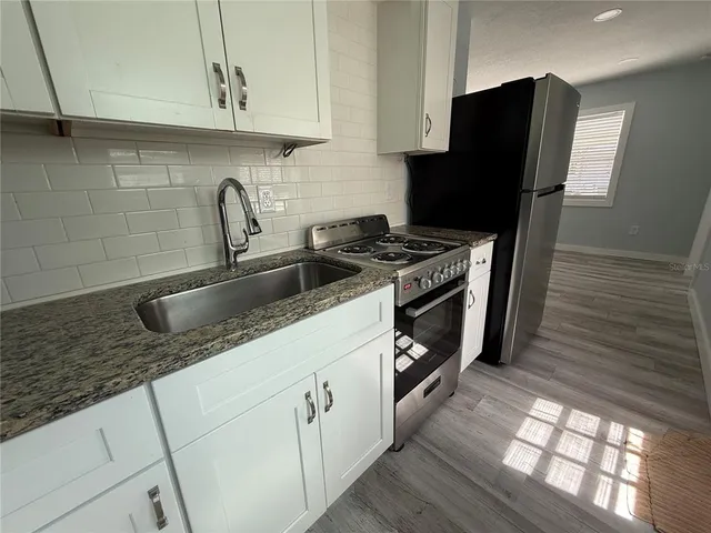 a kitchen with stainless steel appliances granite countertop a sink stove and refrigerator