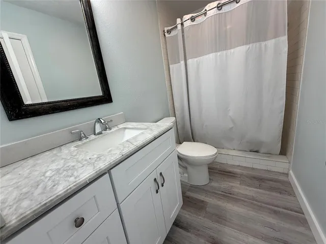 a bathroom with a granite countertop sink toilet and shower